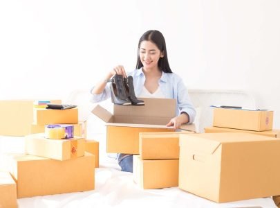 Asian woman packing shoes in a box